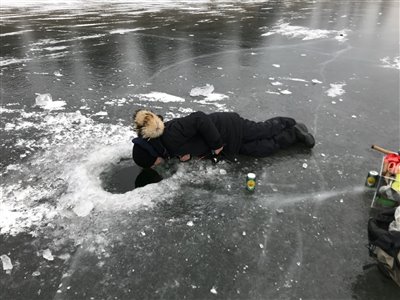 Der kigges efter fisk igennem hullet i isen.