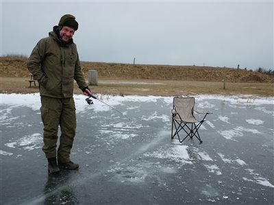 Finn jigger efter en ørred igennem isen.